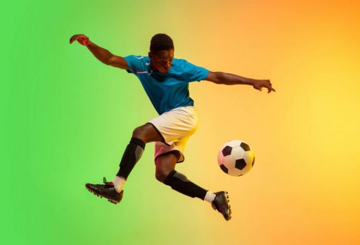 male-soccer-football-player-training-in-action-isolated-on-gradient-studio-in-neon-light-1-690x515